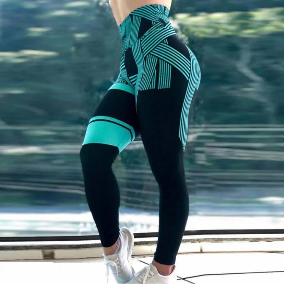 Woman wearing geometric high-waist performance leggings in teal and black for gym and workout