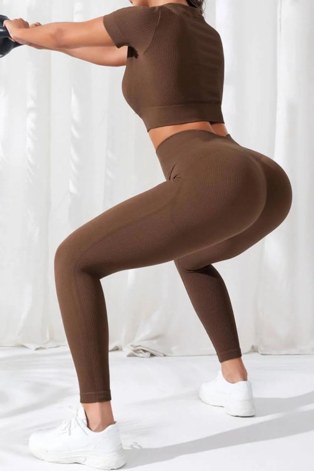 Woman in brown Women’s Seamless V-Neck Crop Top & High-Waist Leggings Set performing yoga pose on white background.