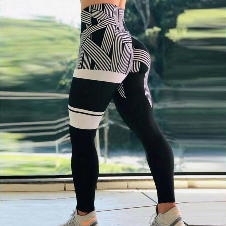 Woman wearing geometric high-waist performance leggings with black and white pattern, showcasing high-waist design and tummy control.